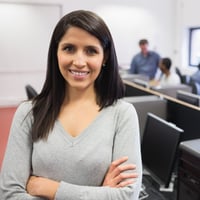 Woman smiling and standing in the front of the computer class-1 Woman smiling and standing in the front of the computer class-1