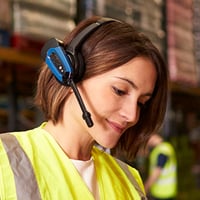 Photograph of a woman wearing safety equipment working in a warehouse.