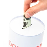 An image of a hand putting money in a donation box An image of a hand putting money in a donation box