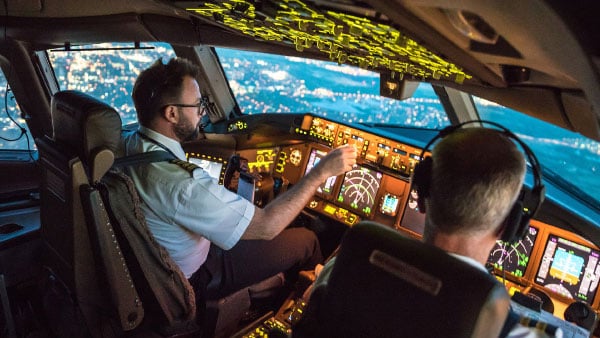 Two pilots flying over a city