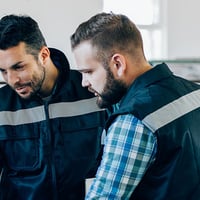 An image of a man talking to a worker in a factory